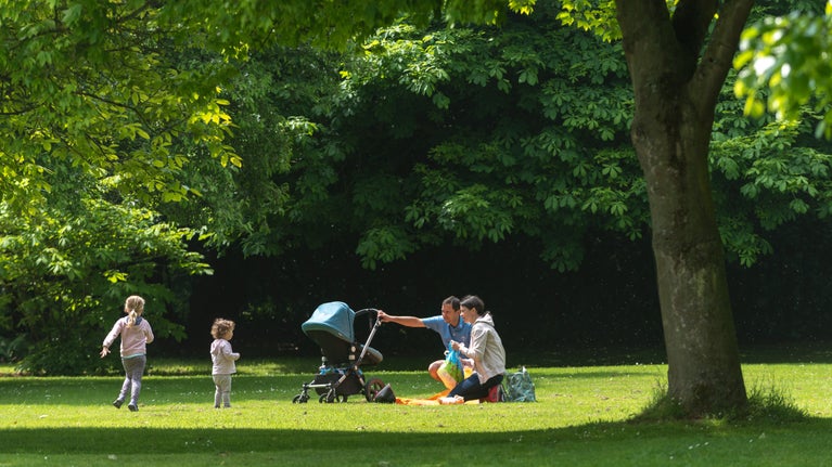 Family enjoying a picnic in the garden amongst the trees at Ormesby Hall
